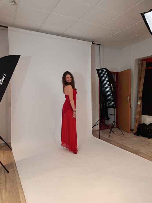 kobieta w czerwonej sukni pozuje do zdjęcia w toruńskim studio jgfotografia